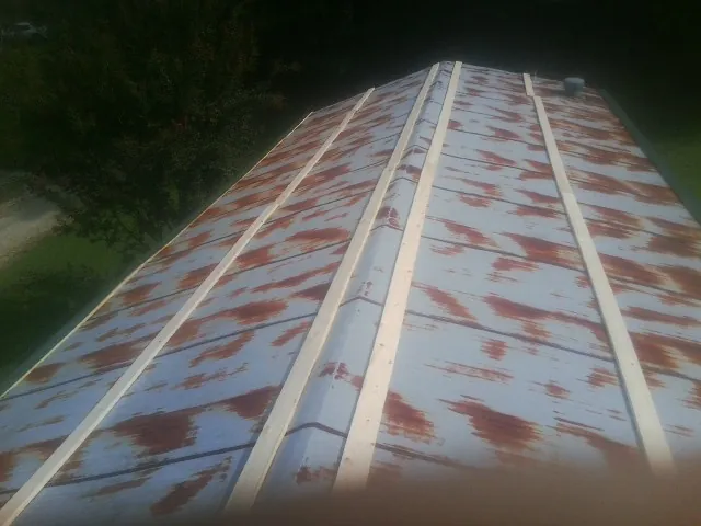 Rusted metal roof panels with new wood purlins before replacement — Storm Damage Roof Repair in Gray Court by Roofing Brothers