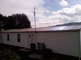 New metal roof on a single wide mobile home with a TV antenna in Gray Court