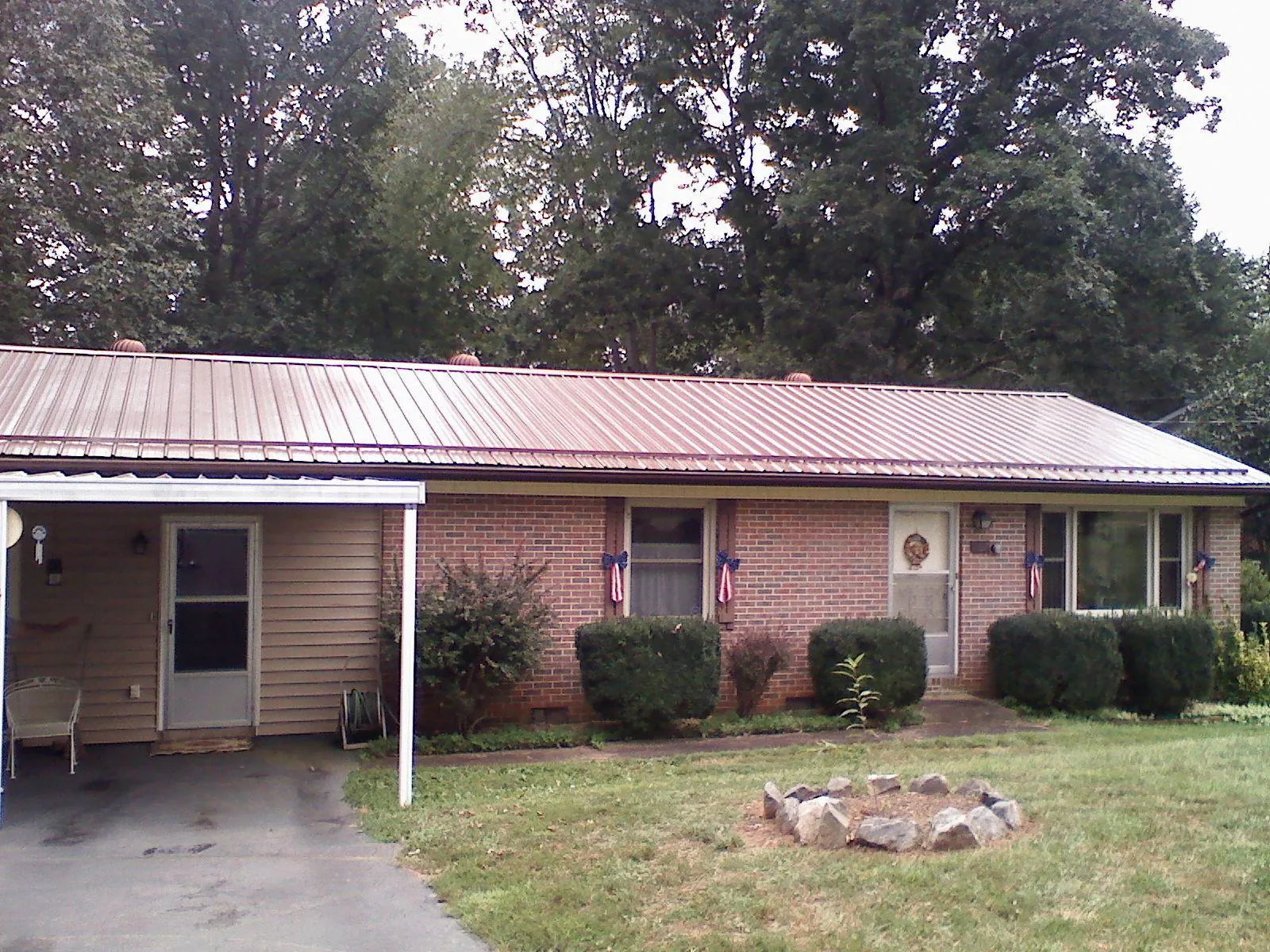 Bronze metal roof and carport on a brick ranch home — Roof Repair work by our crew in Gray Court